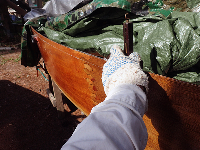 Marking the bottom edge of the teak gunwales with a scribe.